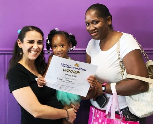Two mothers and their daughter holding a certificate as the winner of the Round Rock free swim party raffle