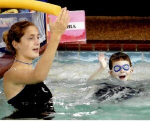 Emler Swim instructor Sophia McKenzie in the pool teaching a swim lesson to kids