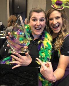 Two Emler Swim School employees with the award for Top 15 Best Places to Work in Houston